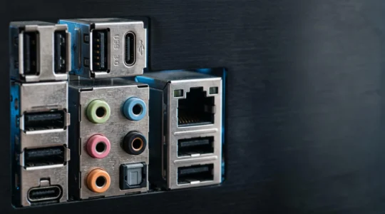 Gros plan artistique sur le panneau arrière d'une carte mère montrant l'organisation stratégique des ports USB, audio et réseau