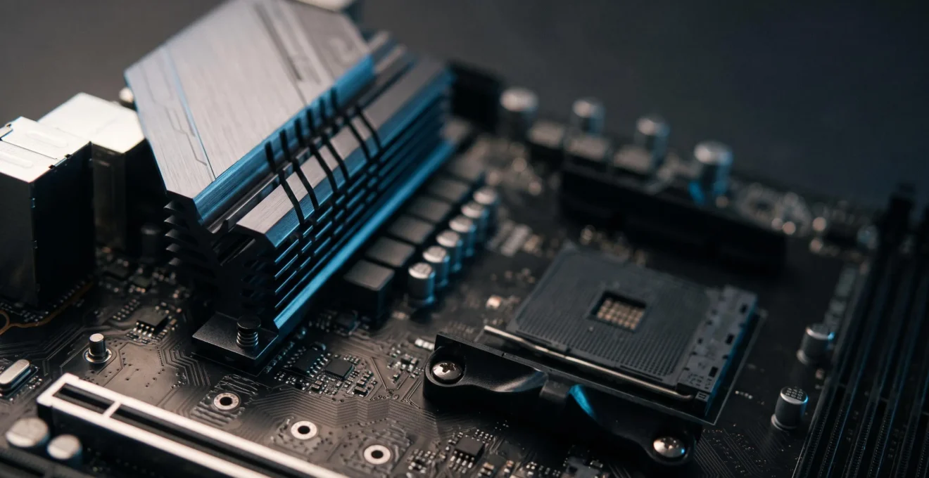 Vue rapprochée d'une carte mère avec son chipset refroidi par un dissipateur metallique, symbolisant le controle et l'optimisation d'une configuration informatique